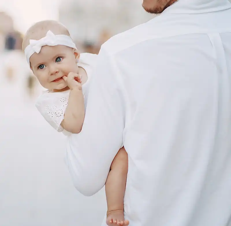 enfant tenu dans les bras de son parent